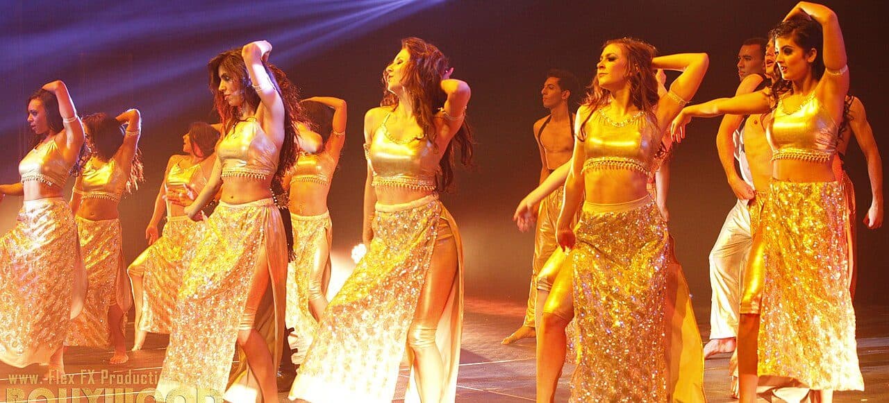 Bollywood dance ensemble on a lit stage